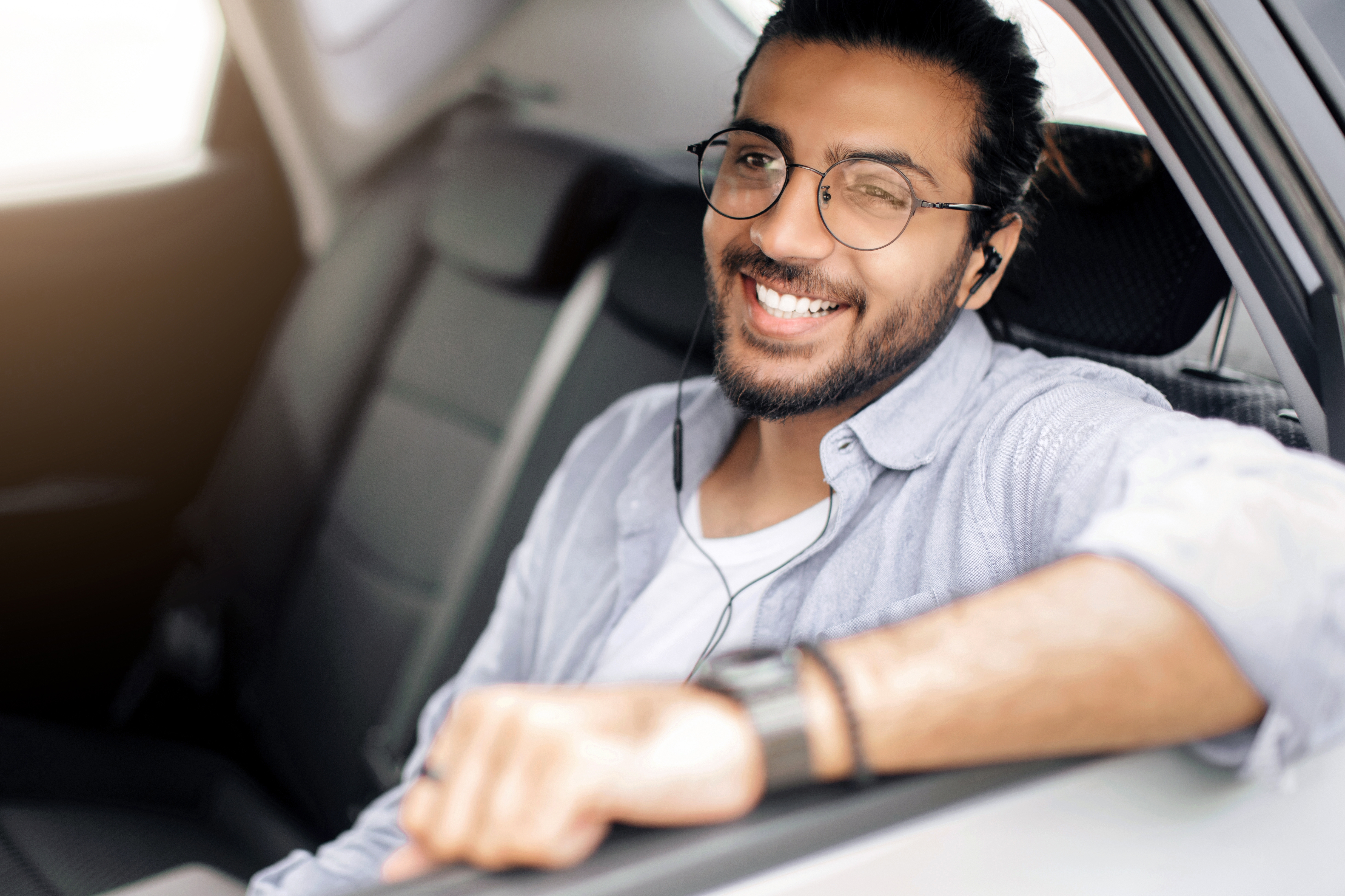 Woman in car using mobile audio tour with headphones